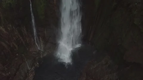 Water falls into pool below waterfall Video stock 160980130