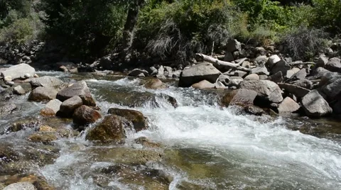 Water Falls Quickly Over Rocks in a River Stock Footage 54375396
