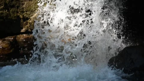 Water falls through a sunlight spot into a pool (slow motion) 스톡 동영상 219394483