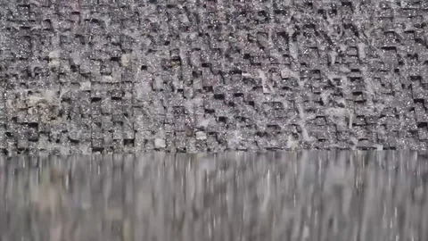 Water falls on a wall covered with small bricks. Stock Footage 113548172