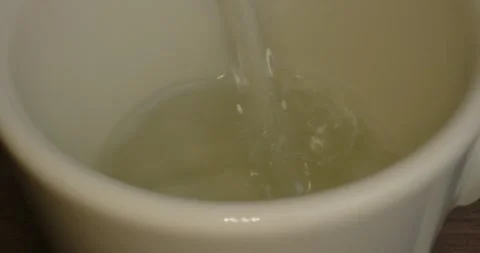 Water is filled into the ceramic cup - Macro Shot Stock Footage 243301575
