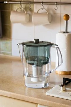 Water filter jug on kitchen table. Clean water concept. Filtration water Stock Photos