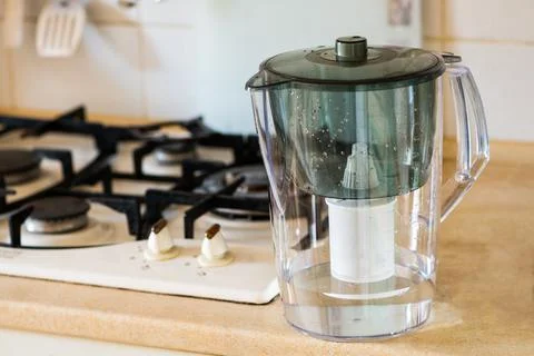 Water filter jug on kitchen table. Clean water concept. Filtration water Stock Photos