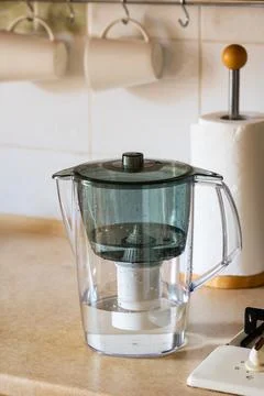 Water filter jug on kitchen table. Clean water concept. Filtration water Stock Photos