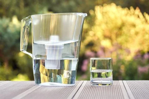 Water filter pitcher and a clean glass of a clear water close up on the summe Foto stock
