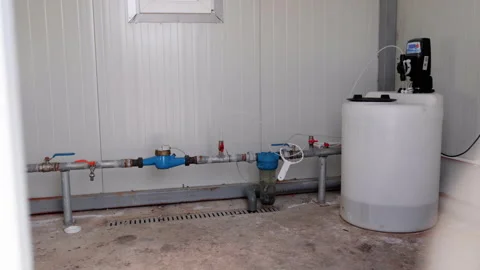 Water filtration system installation process showing pipes, valves, and a Video stock 336063885