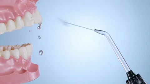 Water flosser cleaning teeth on blue Stock Footage 139651012