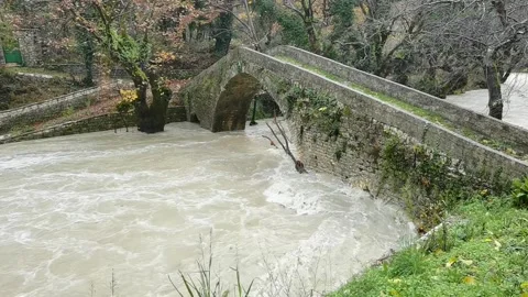 Water flow after rain in old bridge of vrosina bridge ioannina greece Stock Footage 166127972