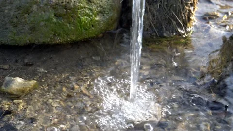 Water flow and splash at mossy stone background Stock Footage 156324424