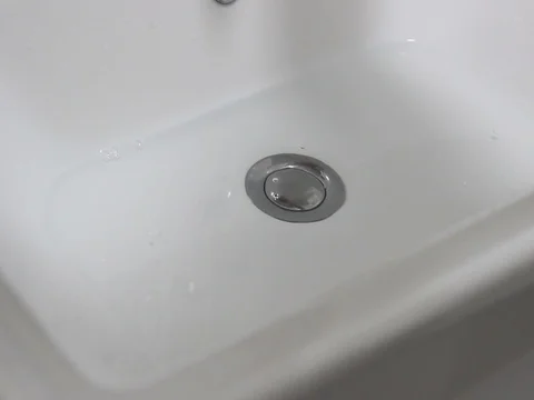 Water flow into drain in bath Stock Footage 125802344