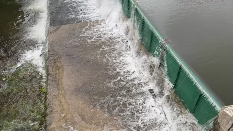 Water flow over plastic dam barrier as protection from rain storm flood Stock Footage 344916709