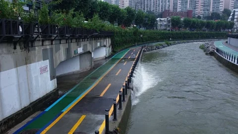 Water flow over sidewalk into swollen river after heavy rain in Seoul Vídeo Stock 246131221