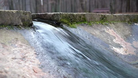 The water flow of a small artificial waterfall on a cold fall day Stock Footage 167167626