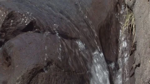 Water flow of a stream flowing on the volcanic rock Stock Footage 52059815