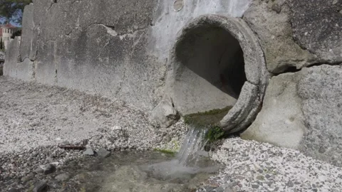 Water Flowing from Algae Covered Drain Pipe. Sde shot Stock Footage 312292789