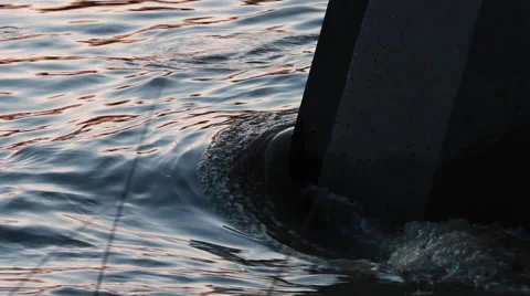 Water flowing around bridge support at dusk Stock Footage 49166095
