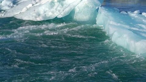 Water flowing around ice Stock Footage 73256140