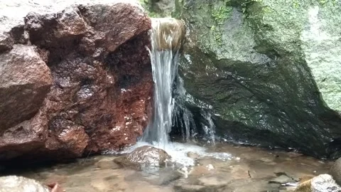 Water Flowing Between Large Rocks in Forest Stream Stock Footage 329775589