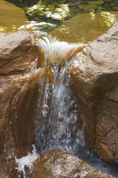 Water flowing between rocks Stock Photos