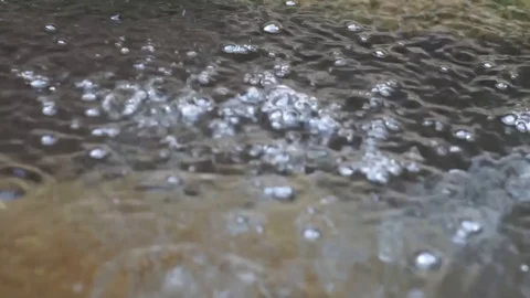 Water flowing closeup, mountain stream in a forest, splashes, bubbles and bokeh Stock Footage 117362612