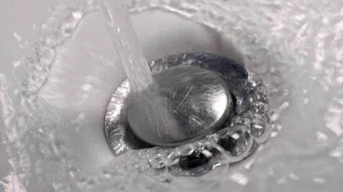 Water flowing down the drain. Drain the water in the sink. Slow motion shot Video stock 122918073