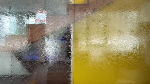 Water flowing down on a glass panel creating a distortion effect Stock Footage 318284235