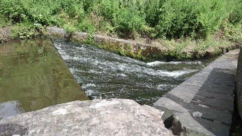 Water flowing down overflow on Trent-and-Mersey canal in Stoke-on-Trent Vídeos de archivo 135473604