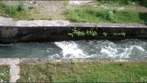 Water flowing fast with white foam in concrete canal Stock Footage 346540228