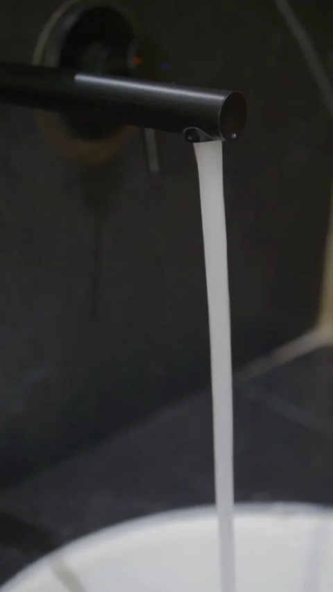 Water flowing from a faucet into a sink in a home setting Stock Footage 346988853