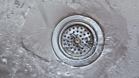 Water flowing going down the drain in stainless steel kitchen sink. HD video. Stock Footage 104108403