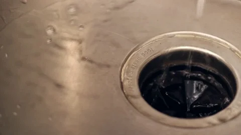 Water flowing into a kitchen sink drain Stock Footage 82041806