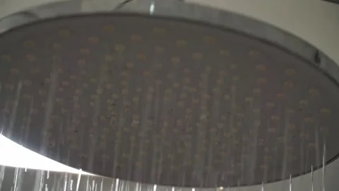 Water flowing from modern shower head close up, bathroom cleanliness and Stock Footage 343425227