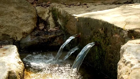 Water flowing from a natural spring emerging from the rock. Stock Footage 334345343