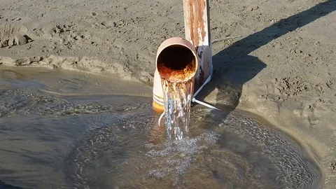 Water flowing out of pipe at beach Stock Footage 72717183