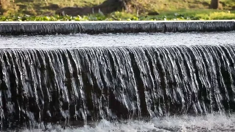 Water flowing over  river dam Stockbeeldmateriaal 79660041