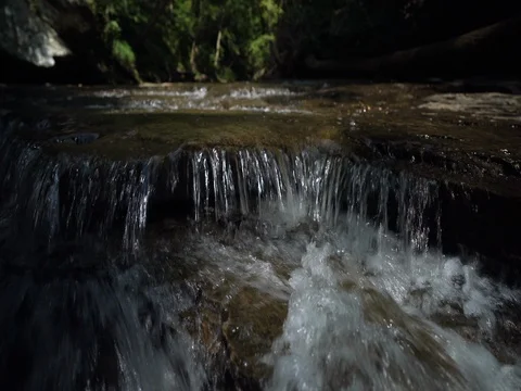 Water flowing over rocks as camera moves down stream Stock Footage 77149990
