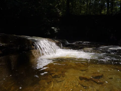 Water flowing over rocks in small stream Stock Footage 77167834