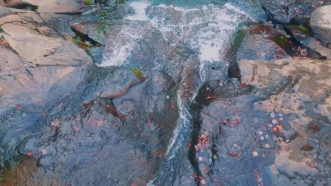 Water flowing over rocks in a stream or river Stock Footage 323972547