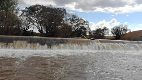 Water flowing over a small wall in the Vaal River Stock Footage 310318656