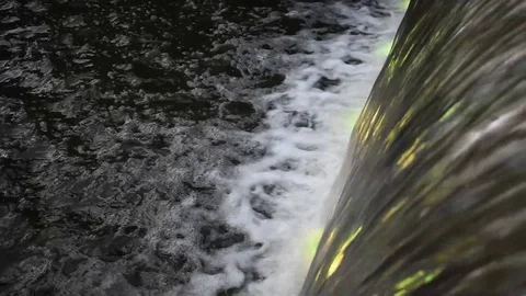Water flowing into pond with changing lights Stock Footage 76563357
