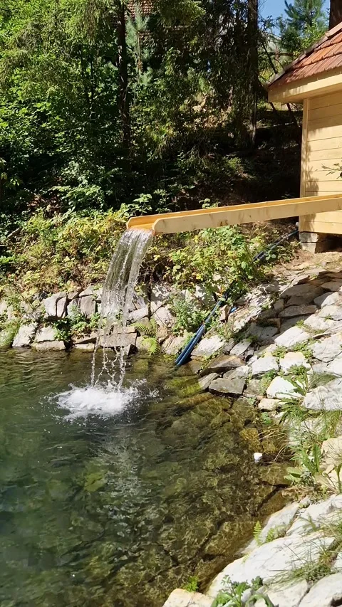Water Flowing into Pond from Rustic Cabin Spout Stock Footage 318347053