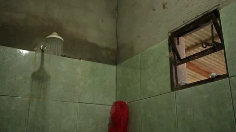 Water flowing from a showerhead in a rustic bathroom, Xinguara, Pará Stock Footage 317793768