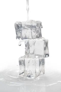 Water flowing on a stack of melting ice cubes on white background 스톡 사진