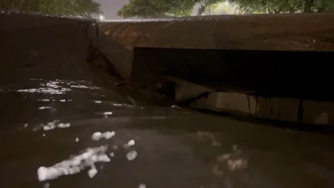 Water flowing into storm drain in Austin, Texas 5/30/2025 Stock Footage 310413253