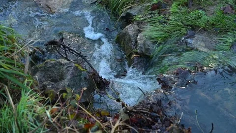 Water flowing in a stream at a small waterfall in winter Stock Footage 323154945