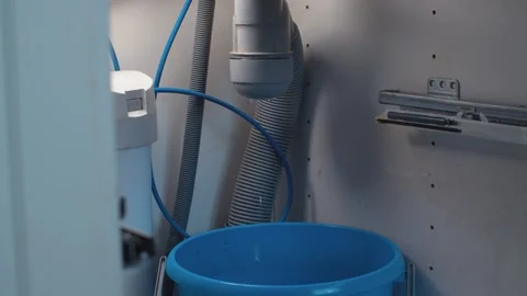 Water flowing from a syphon under the kitchen sink Stock Footage 131179435