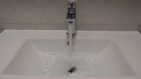 Water flowing from tap to bathroom sink. Save water. Stock Footage
