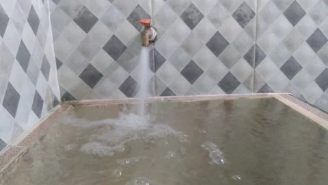 Water flowing from the tap which is accommodated in the bin Stock Footage 276317700