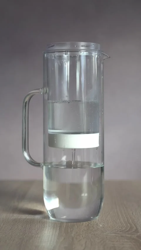 Water flowing through filter in glass carafe jug Stock Footage 229652207