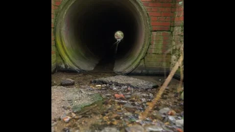 Water Flowing Through a Large Drainage Culvert Under a Brick Structure Stock Footage 304764573